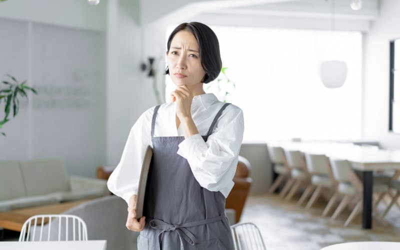 悩む飲食店の女性店員